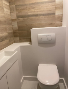 Dans les toilettes, un meuble sur-mesure intègre la vasque et le bâti-support des WC.